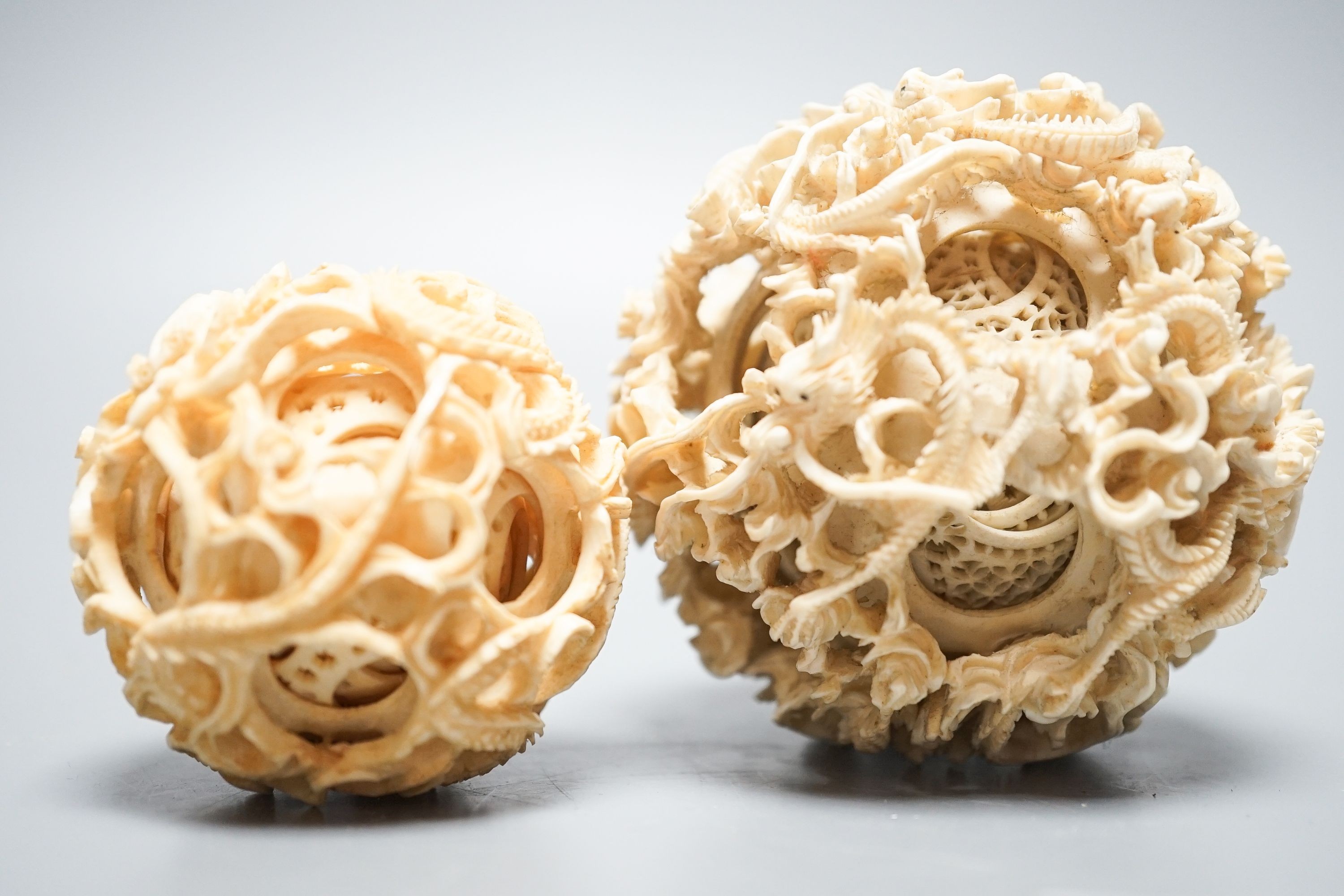 Two Chinese concentric ivory puzzle balls, first half 20th century, largest 8.6cm